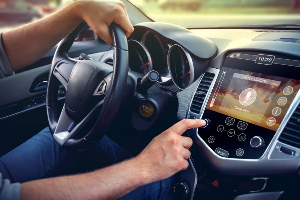 car driver adjusting car stereo