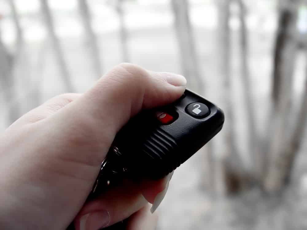 woman presses on remote car starter in winter